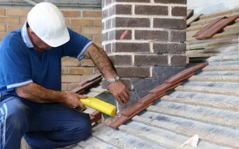 Un couvreur installe un solin en plomb pour l'étanchéité de cheminée, assurant une protection durable contre les intempéries.