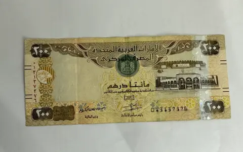 Banknot 200 dirhamów, waluta w Dubaju, z wizerunkiem sokoła i budynków.