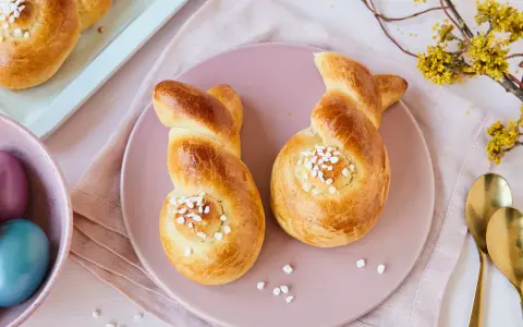 Zwei goldbraune Hefehasen mit Zuckerkristallen, bereit zum Osterfrühstück. Das Backen von Hefehasen ist eine schöne Tradition.