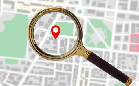 Lupa powiększa mapę z zaznaczonym punktem, sugerując, jak sprawdzić IP komputera.