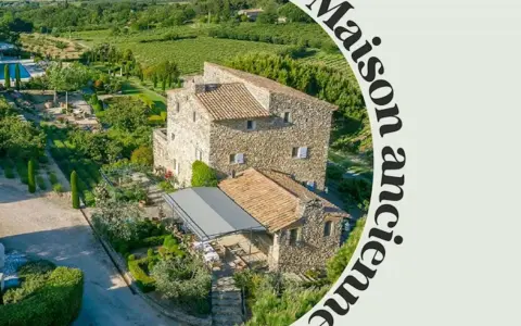 Magnifique maison provençale en pierre, entourée de jardins luxuriants, de vignobles et d'une piscine.