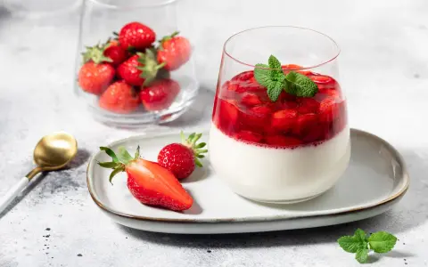 Délicieux panna cotta fraise, garni de fruits rouges frais et d'une touche de menthe. Un dessert léger et fruité.