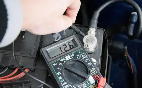 Pomiar napięcia akumulatora multimetrem. Wynik 12.6V wskazuje na dobry stan.