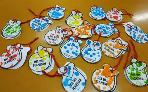 Manualidades flamencas para niños: castañuelas de papel con huellas dactilares de colores, decoradas para el Día del Flamenco.