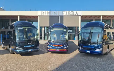 Tre bus Bonelli Bus blu scuro pronti per il viaggio da Rimini a San Marino, con la scritta "Rimini Fiera" sullo sfondo.