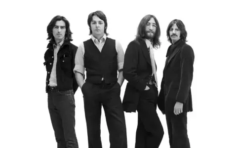 Les quatre membres des Beatles posent pour une photo en noir et blanc.