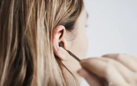 Une personne utilise un outil pour nettoyer son oreille. Les boules quies me font mal aux oreilles, alors je préfère cette méthode.
