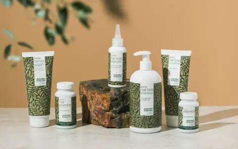 En samling hårvårdsprodukter med biotin, inklusive schampo, balsam, serum och kosttillskott. Biotin mat för starkare hår.