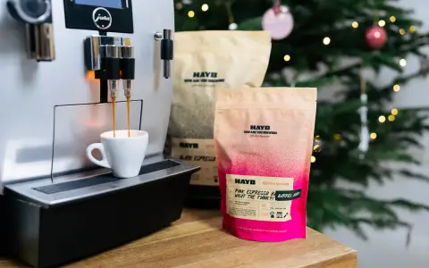 Espresso z ekspresu Jura, obok paczki kawy HAYB "Pink Espresso Barrel Aged". W tle choinka.