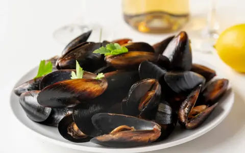 Plato de mejillones al vapor, listos para disfrutar con un toque de limón y perejil.