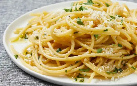 Pyszny makaron aglio e olio, idealny pomysł, z czym zrobić makaron na szybko. Posypany parmezanem i natką pietruszki.