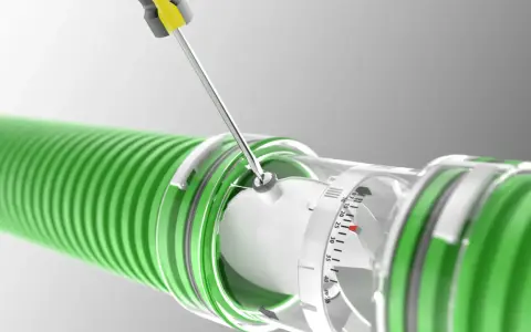 A screwdriver adjusts a clear dial on a green hose, indicating the regulador caudal.