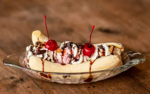 Un déliceux banana split avec glace, crème fouettée, pépites de chocolat et cerises. Une recette parfaite pour un dessert gourmand.