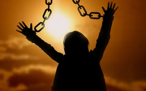 Silhouette einer Person, die sich von Ketten befreit, symbolisiert die Vergebung, wie sie in der Bibel gelehrt wird.