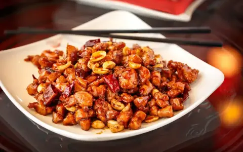 Kurczak Kung Pao, jak Król Małp, w sosie z orzeszkami ziemnymi i papryczkami chili.
