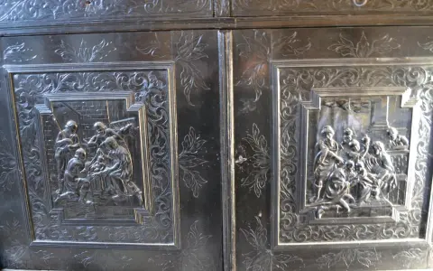 Détail d'un meuble Louis XIII sculpté de scènes bibliques et de motifs floraux.
