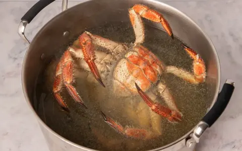 Buey de mar cocinándose en una olla grande con agua hirviendo.