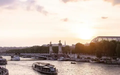 Boote auf der Seine bei Sonnenuntergang, eine malerische Szene, die die beste Reisezeit für Paris widerspiegelt.