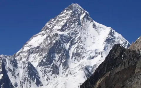 Lodowy gigant K2, najwyższy szczyt Karakorum, wznosi się dumnie na tle błękitnego nieba.