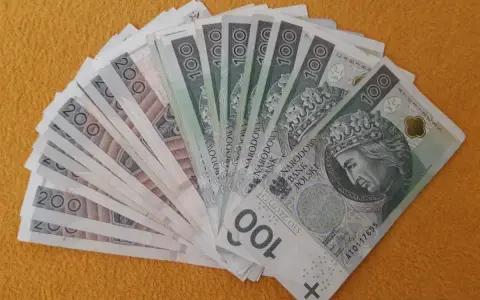 Stos banknotów 100 i 200 zł, gotowy na darowiznę dla dziecka.