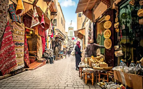 Bunte Teppiche und Souvenirs säumen einen belebten suk markt. Menschen schlendern durch die Gasse, vorbei an Geschäften voller Schätze.