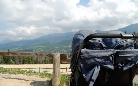 Podwójny wózek gotowy na przygodę. Zastanawiasz się, jakie szlaki z dzieckiem w Zakopanem są najlepsze? Ten widok na Tatry zachęca do odkrywania!