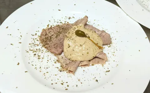 Dünne Scheiben Braten mit einer cremigen thunfischsauce italienisch, garniert mit Kapern und Kräutern.