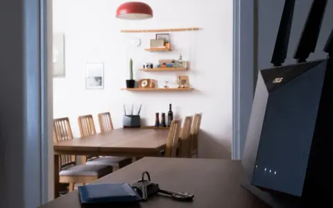 En modern router med wifi 4 ger snabb uppkoppling i hemmet. Nycklar och en blå korthållare ligger på bordet.