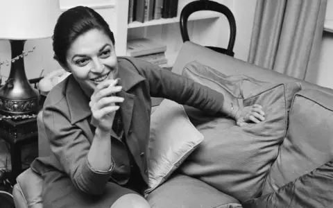 Anne Bancroft sorride con una sigaretta in mano, un'immagine che evoca la sua vivacità, prima che la causa morte la portasse via.