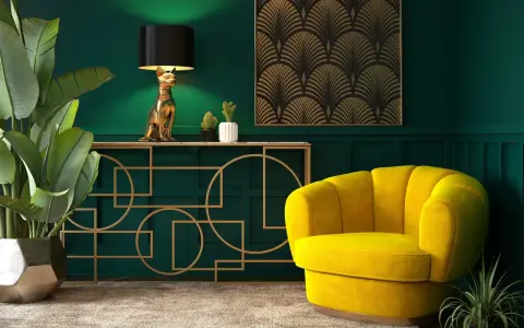 Eleganckie wnętrze w stylu art deco nowoczesny: złoty kot jako lampa, żółty fotel i geometryczne zdobienia na zielonej ścianie.
