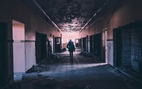 Samotna postać w zrujnowanym korytarzu, symbolizująca zachowania autodestrukcyjne u dorosłych.