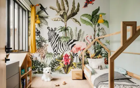 Une chambre d'enfant avec un mur jungle : zèbre, flamant rose, léopard, singe, toucan. Une excellente idée déco chambre enfant pour l'aventure !