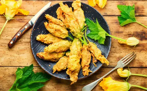 Fiori di zucca in friggitrice ad aria, dorati e croccanti, pronti per essere gustati.