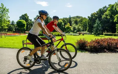 Dwie osoby na rowerach cieszą się słonecznym dniem w parku. Ile czasu zajmie im przejechanie 20 km rowerem?