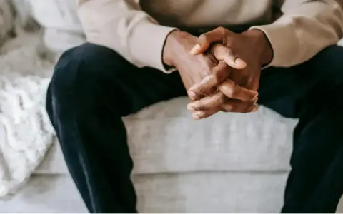 Mains jointes d'un homme, une posture qui peut exprimer le désir, la contemplation ou l'attente.