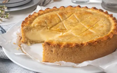 Un delicioso pastel vasco, con su masa dorada y relleno cremoso, listo para ser disfrutado.