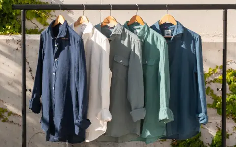 Cinco camisas de lino de colores cuelgan en una percha. El lino, de donde viene el lino, es una fibra natural.
