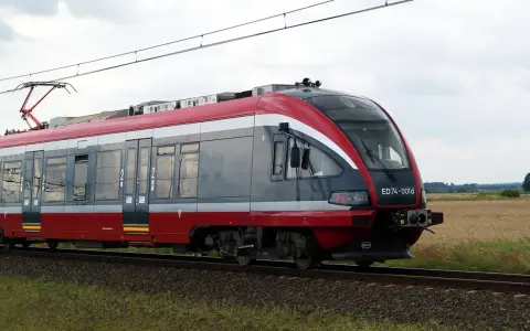 Nowoczesny pociąg PKP, idealny do sprawdzenia pkp busko-zdrój rozkład jazdy. Pędzi przez pola.