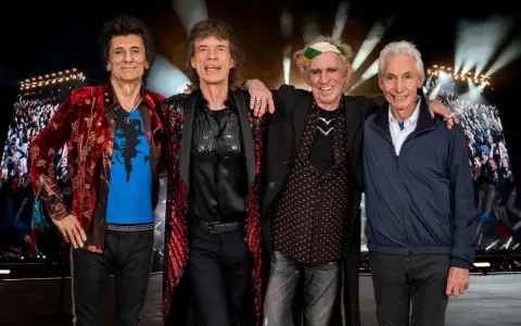 Członkowie The Rolling Stones pozują przed tłumem na jednym z ich niezapomnianych **koncertów**.