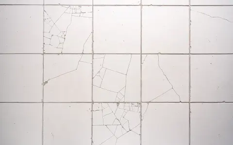 Uszkodzone płytki ceramiczne, widoczne pęknięcia tworzą mozaikę. Reklamacja płytek po położeniu jest konieczna.