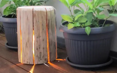 Un tronco di legno con fessure illuminate, un'idea creativa per come costruire una fioriera in legno.
