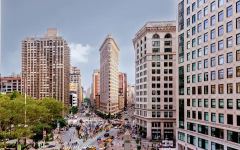 Vista aérea de Nueva York con el icónico edificio Flatiron en el centro. Los planos de la ciudad muestran la intersección de calles y la arquitectura circundante.