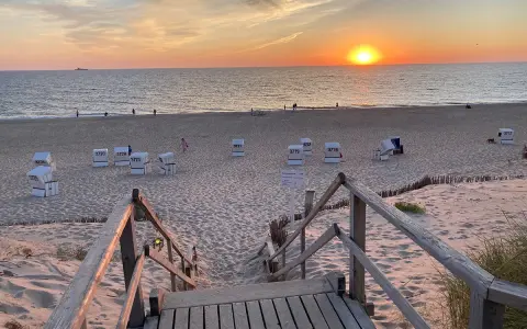 Sonnenuntergang am Strand von Sylt. Strandkörbe warten auf Besucher, die die schönen Ausflugsziele Sylt genießen.