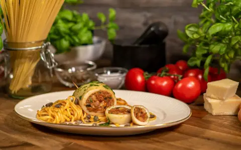 Seppie ripiene auf Pasta mit Kapern, Tomaten und Parmesan.
