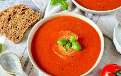 Cremige Tomatensuppe, ein tolles Rezept mit frischen Tomaten, garniert mit Basilikum und einem Klecks Sahne. Dazu knuspriges Brot.