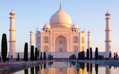 El Taj Mahal, un mausoleo de mármol blanco, se refleja en el agua. Es una maravilla arquitectónica, un símbolo de amor eterno.