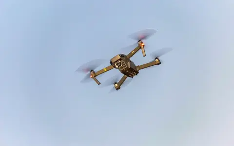 A drone flies in the sky, a reminder to check Maine drone laws before takeoff.