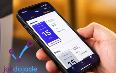 Dłoń trzyma smartfon z otwartą aplikacją jak dojadę, pokazującą aktywne bilety komunikacji miejskiej.