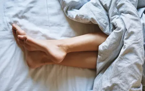 Nogi pod pościelą. Zastanawiasz się, jak często zmieniać piżamę? Czysta pościel to podstawa.