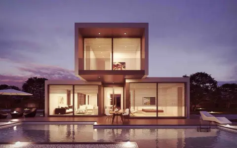 Moderne Villa mit Pool und Terrasse, ideal für den Hausbau planen. Beleuchtete Innenräume und ein schöner Abendhimmel.